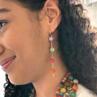 A woman's ear is shown modeling the Kantha Fluid Ellipses Earrings.