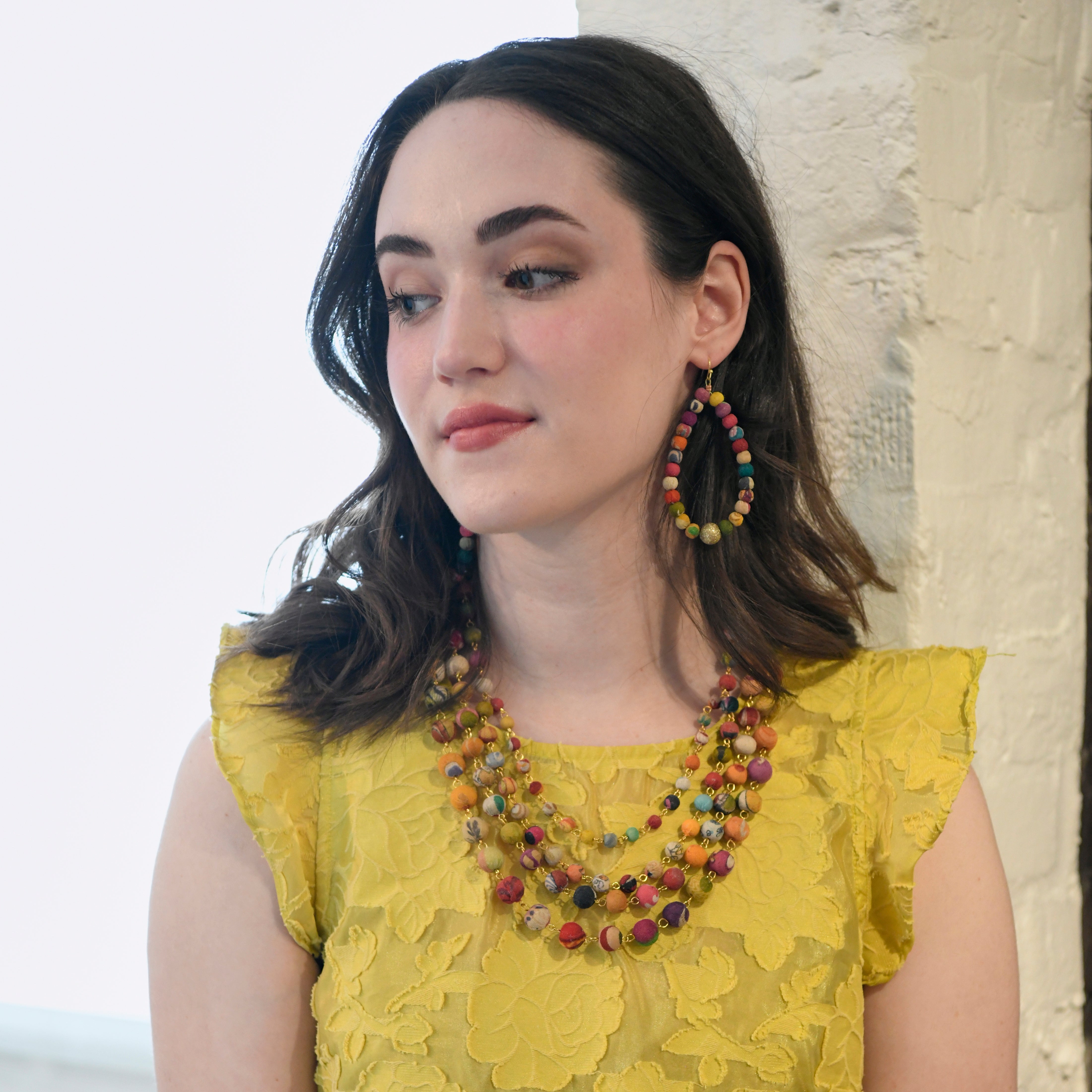 A woman wears the Kantha Karita Necklace.