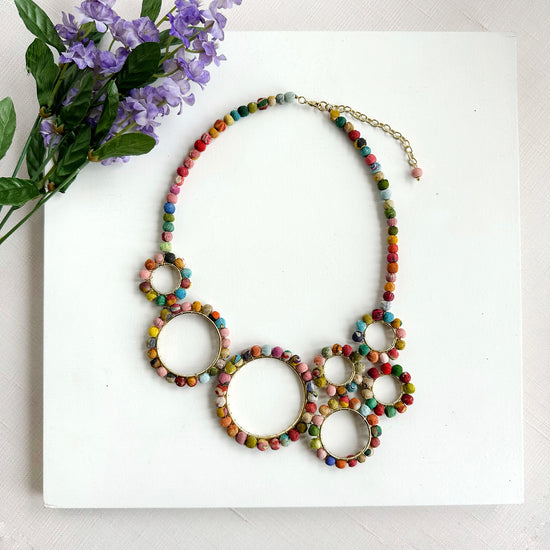 Seven metallic rings are lined with colorful Kantha beads and artfully arranged to create this statement style.