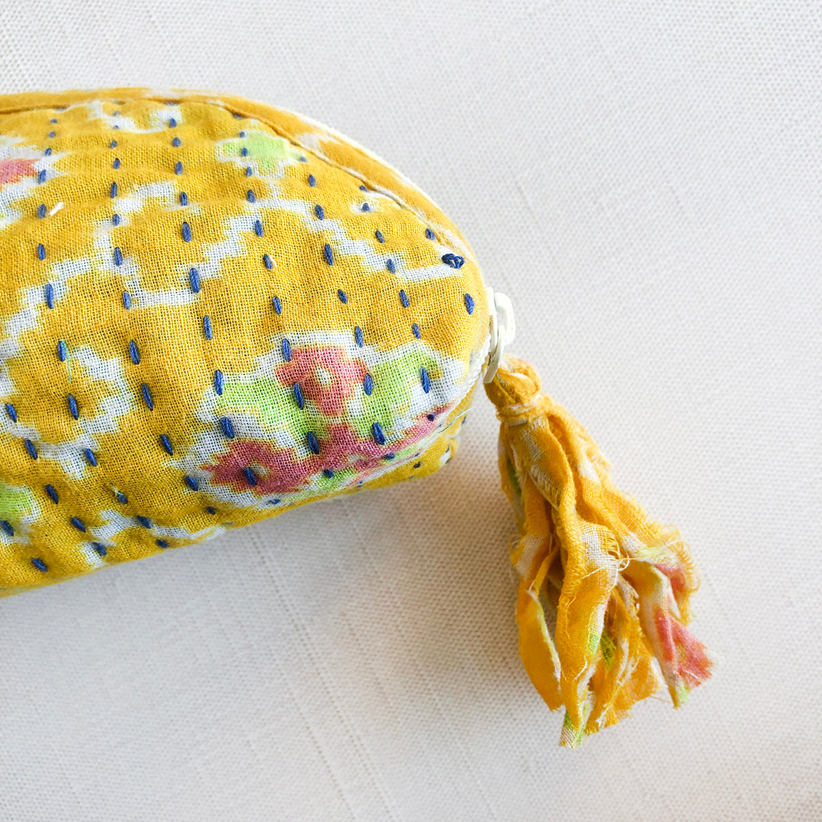 A yellow Kantha Brush Bag is accented with a yellow tassel.