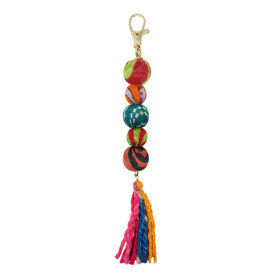 A keychain features five colorful textile-wrapped beads and is finished off with a colorful tassel