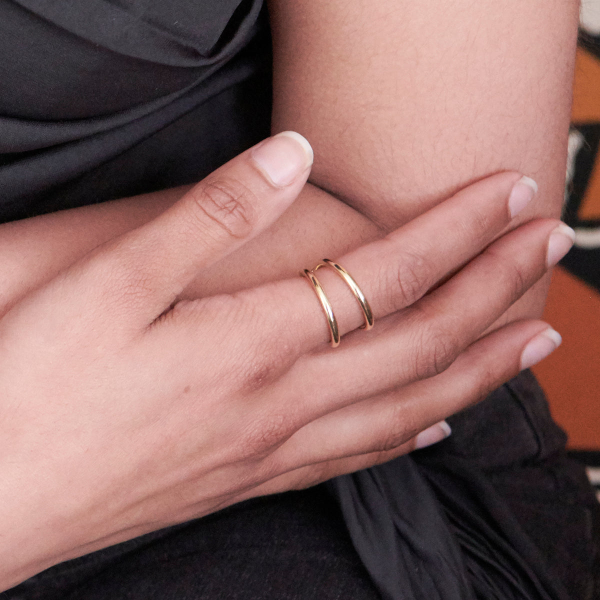 A woman's hand is adorned with a single gold ring.