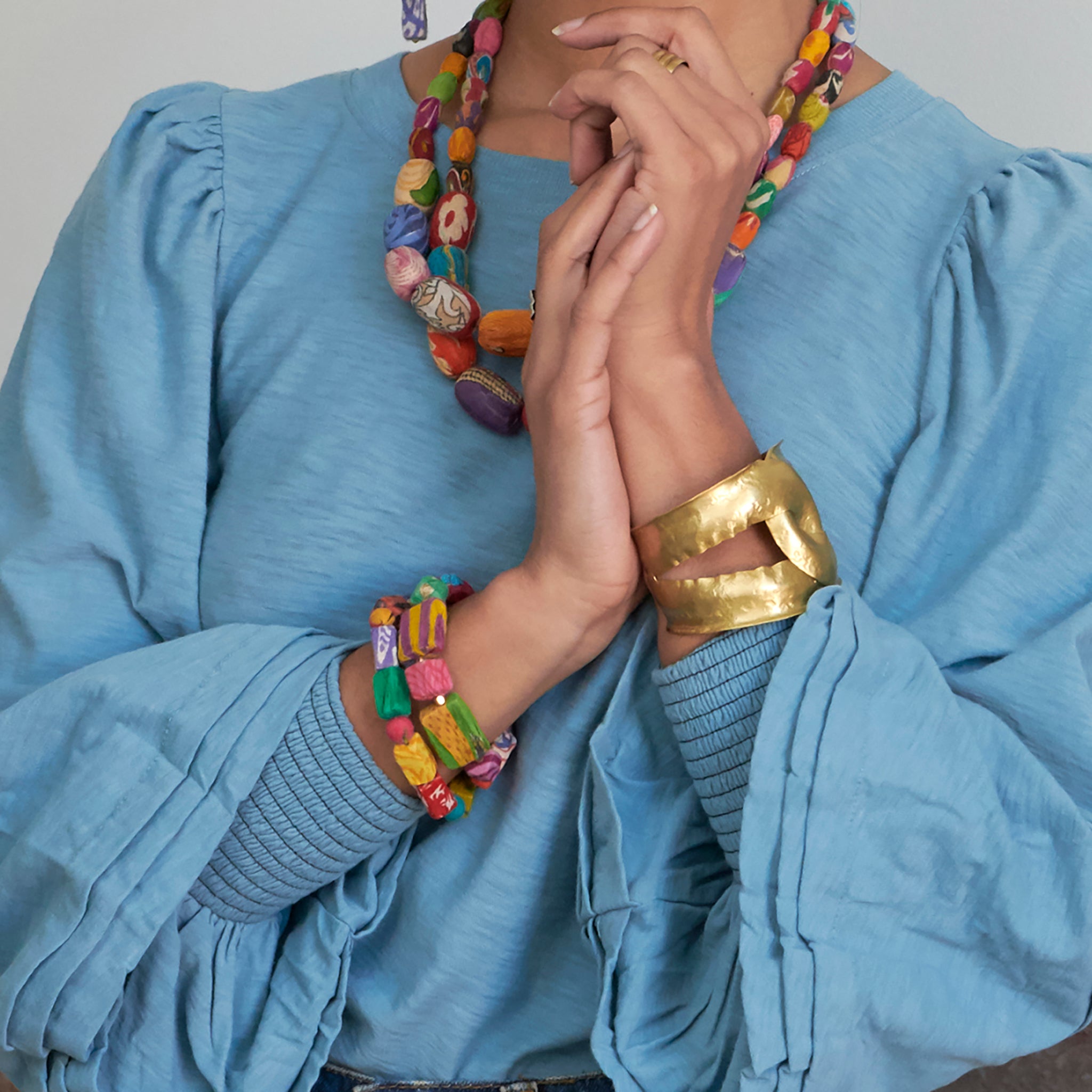 A woman's hands are seen, adorned with various jewelry.