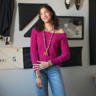 A model smiles while modeling colorful textile-wrapped jewelry.