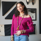 A model smiles at us while modeling colorful textile-wrapped jewelry.