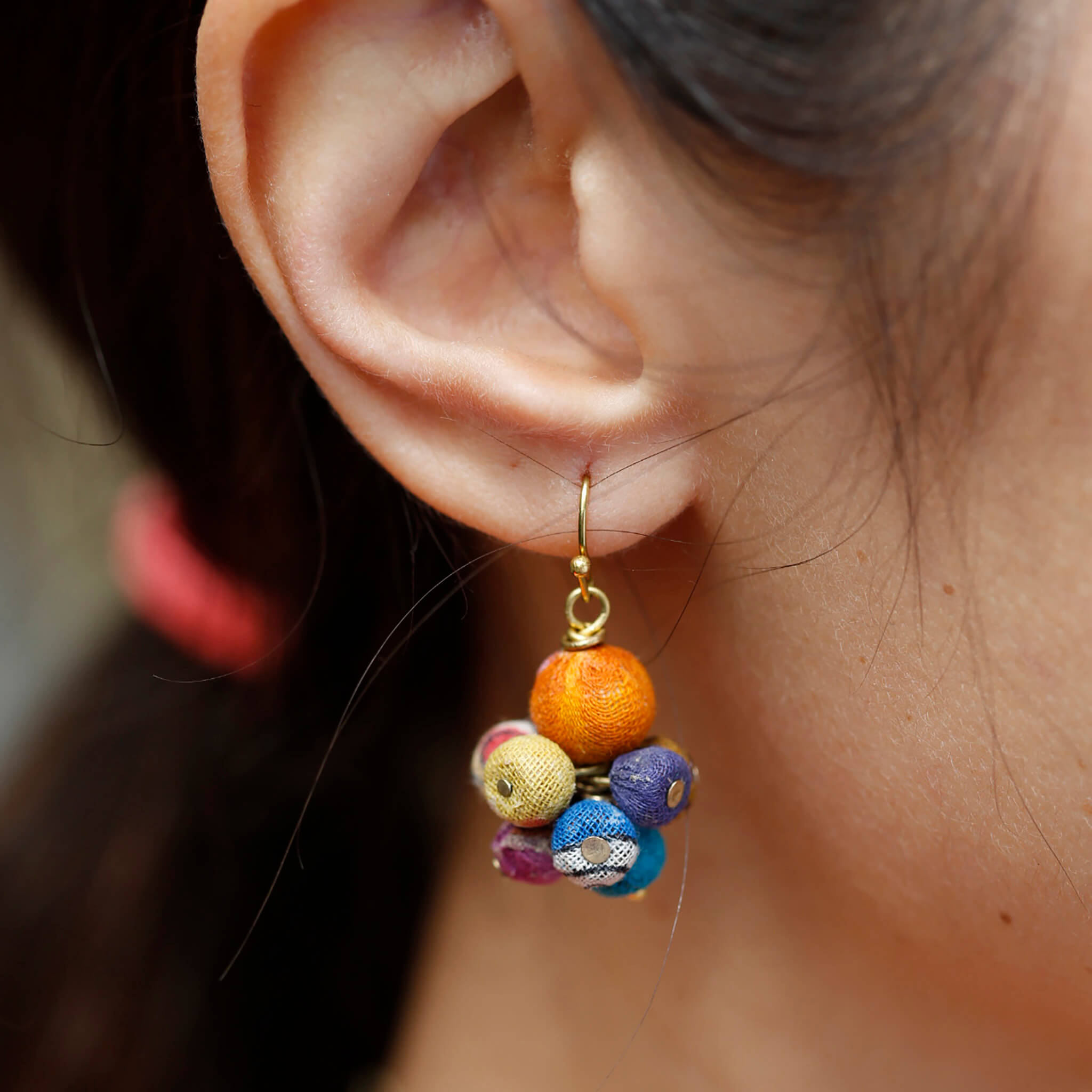A close-up of a woman's ear wearing the Kantha Drop Earrings.