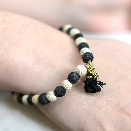 A black and white beaded bracelet is shown on a person's wrist