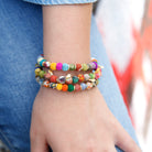 Three multicolored bracelets adorn a wrist
