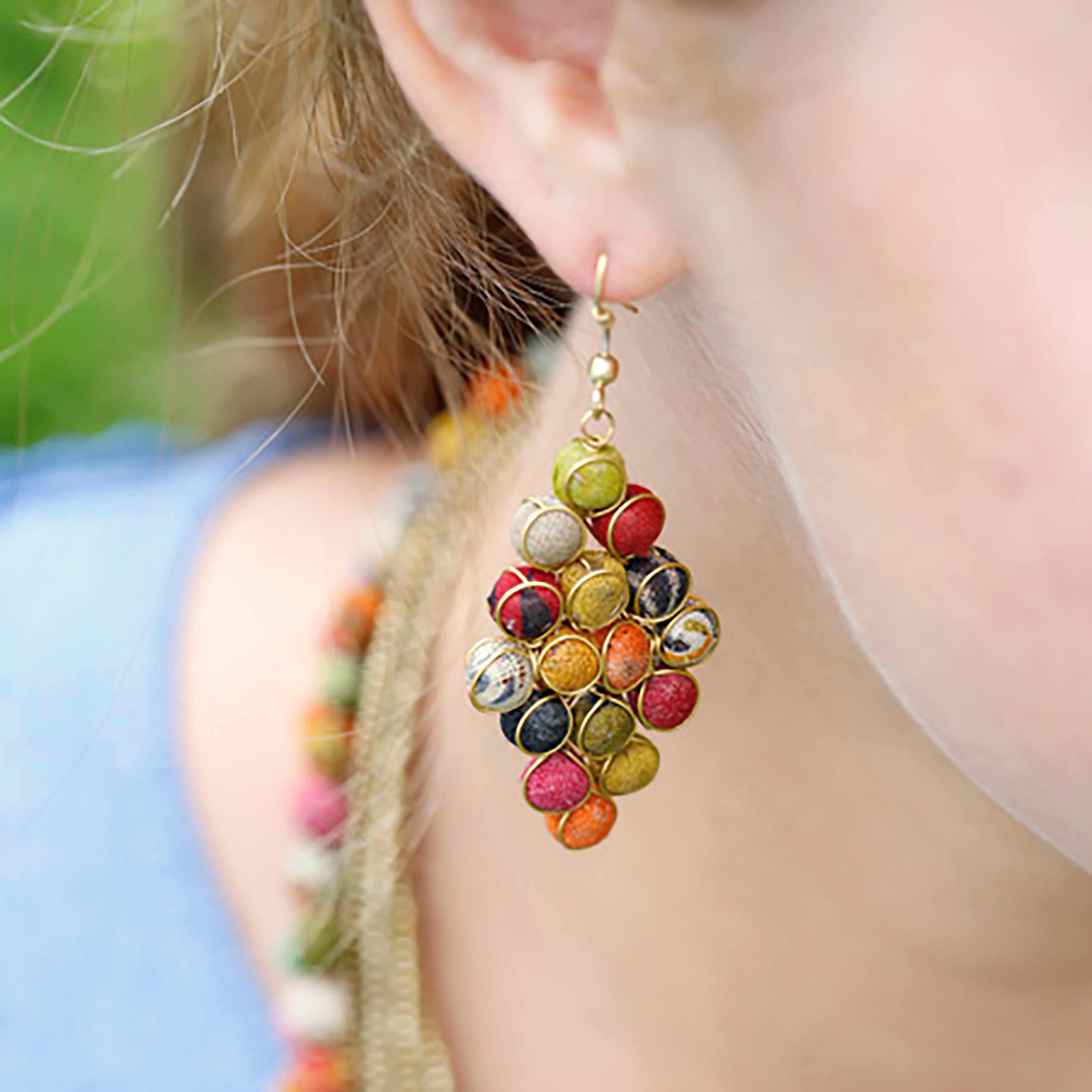 A close up of a woman's ear and the colorful, beaded earring she is wearing.