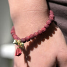 A close up of a woman's wrist and the red beaded bracelet she wears.