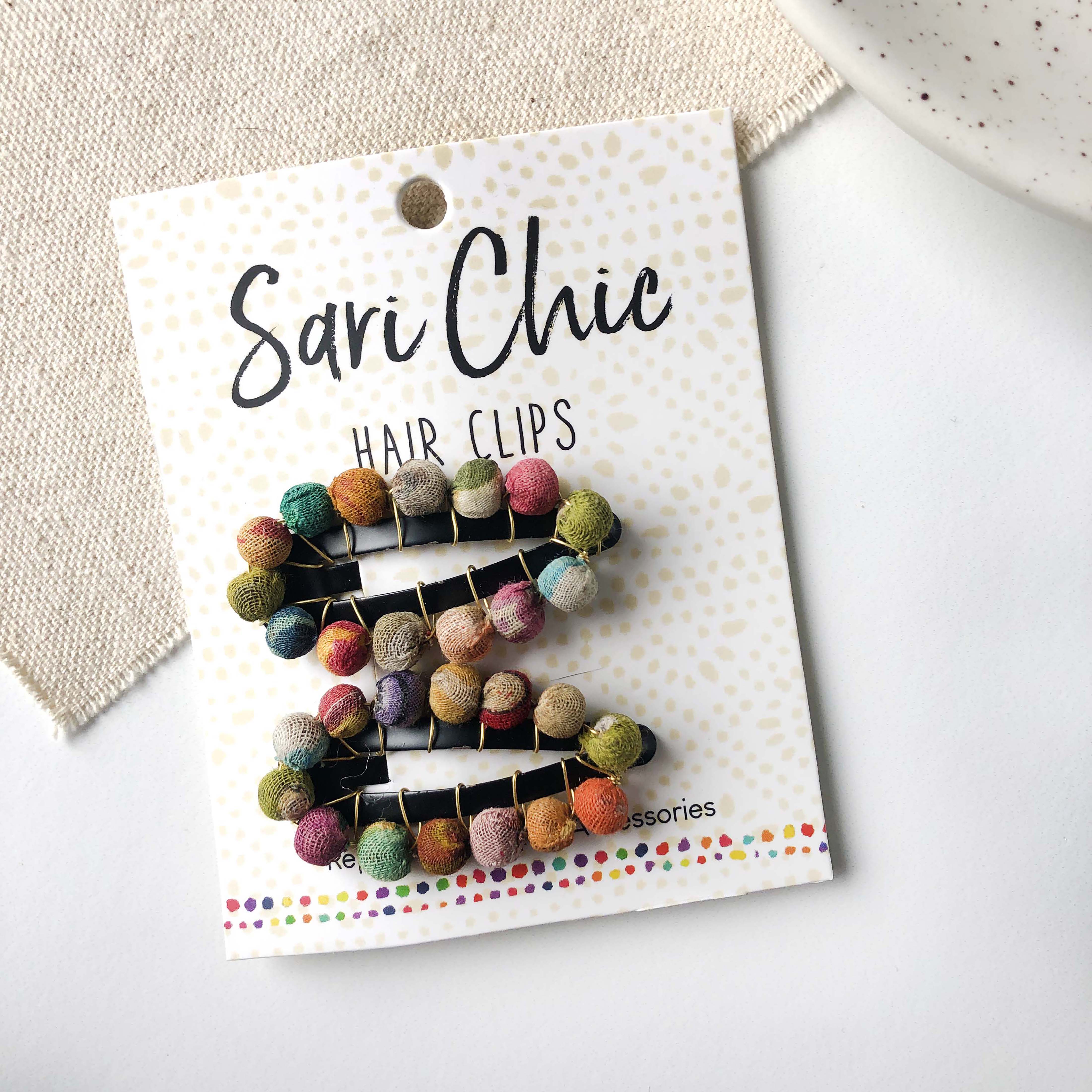 Two hair clips are attached to a card for packaging and rest on a white background.